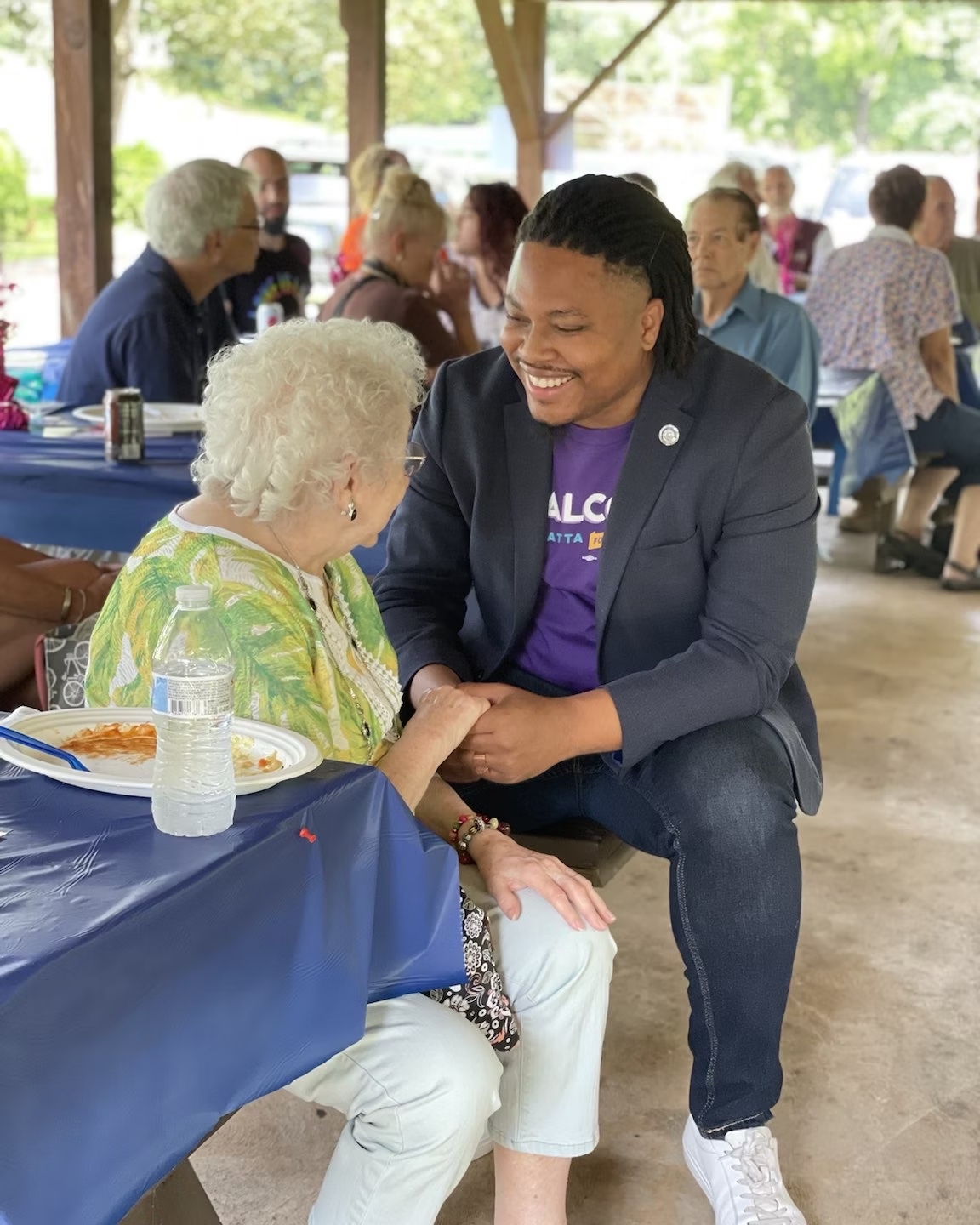 Malcolm Kenyatta speaking with a community member at a community event